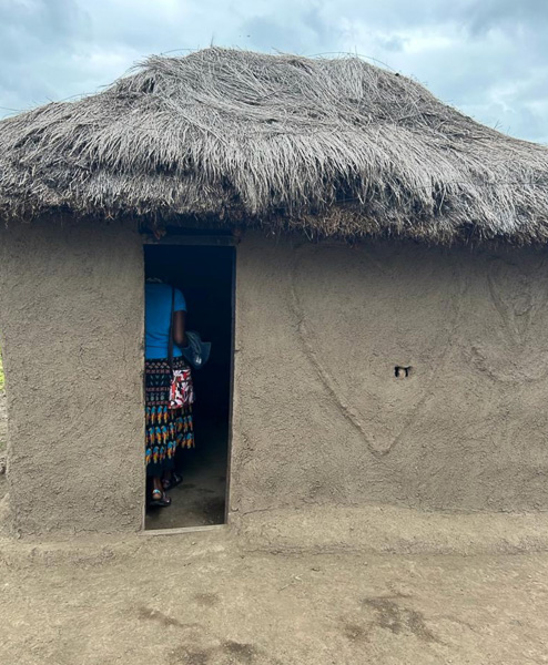 A person in the entrance of their earthen home