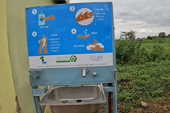 A community water sink and spigot with instructional signage