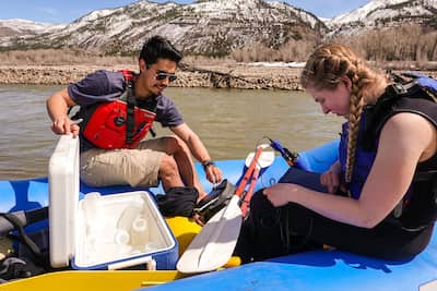 Students in a raft on the river doing an ecology study